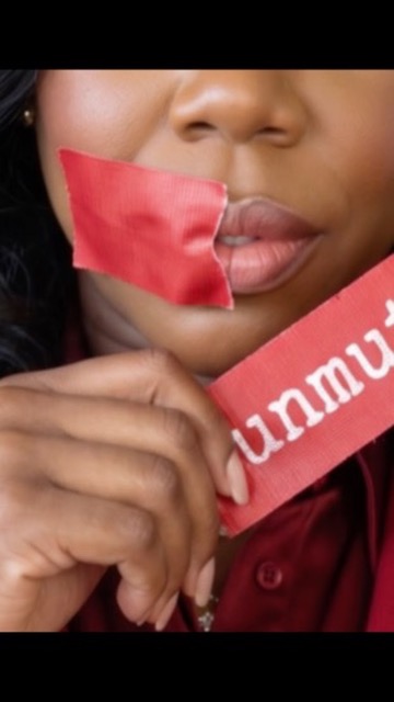 Close-up of red ‘unmuted’ strip being pulled away from lips