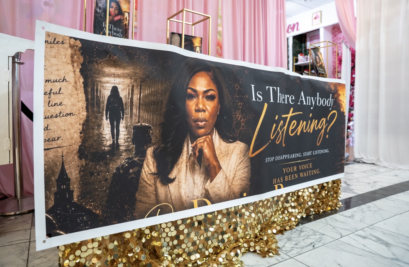 Step-and-repeat banner at the launch event with gold sequin skirting